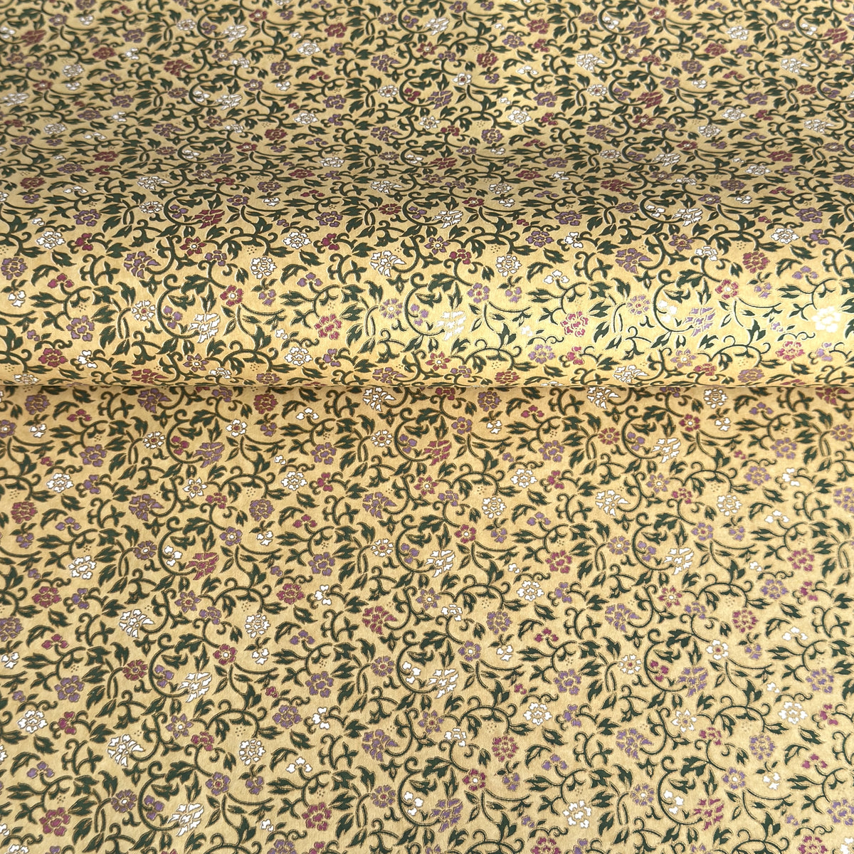 Japanese chiyogami silkscreen paper with a dainty floral pattern on a creamy backdrop and finished with gold metallic ink. 