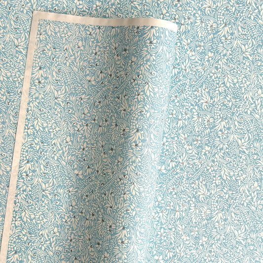 Japanese chiyogami paper - silkscreen printed - light blue backdrop with a small botanical pattern in white with silver accents.