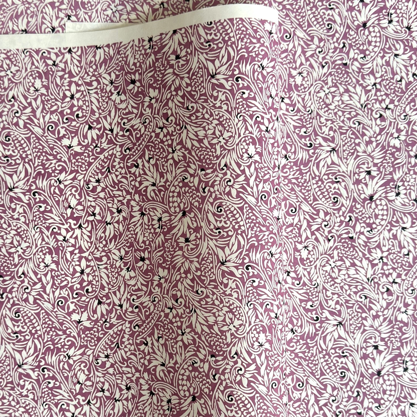 a sheet of Japanese silkscreen printed chiyogami yuzen paper with a micro floral pattern in aubergine, white and black