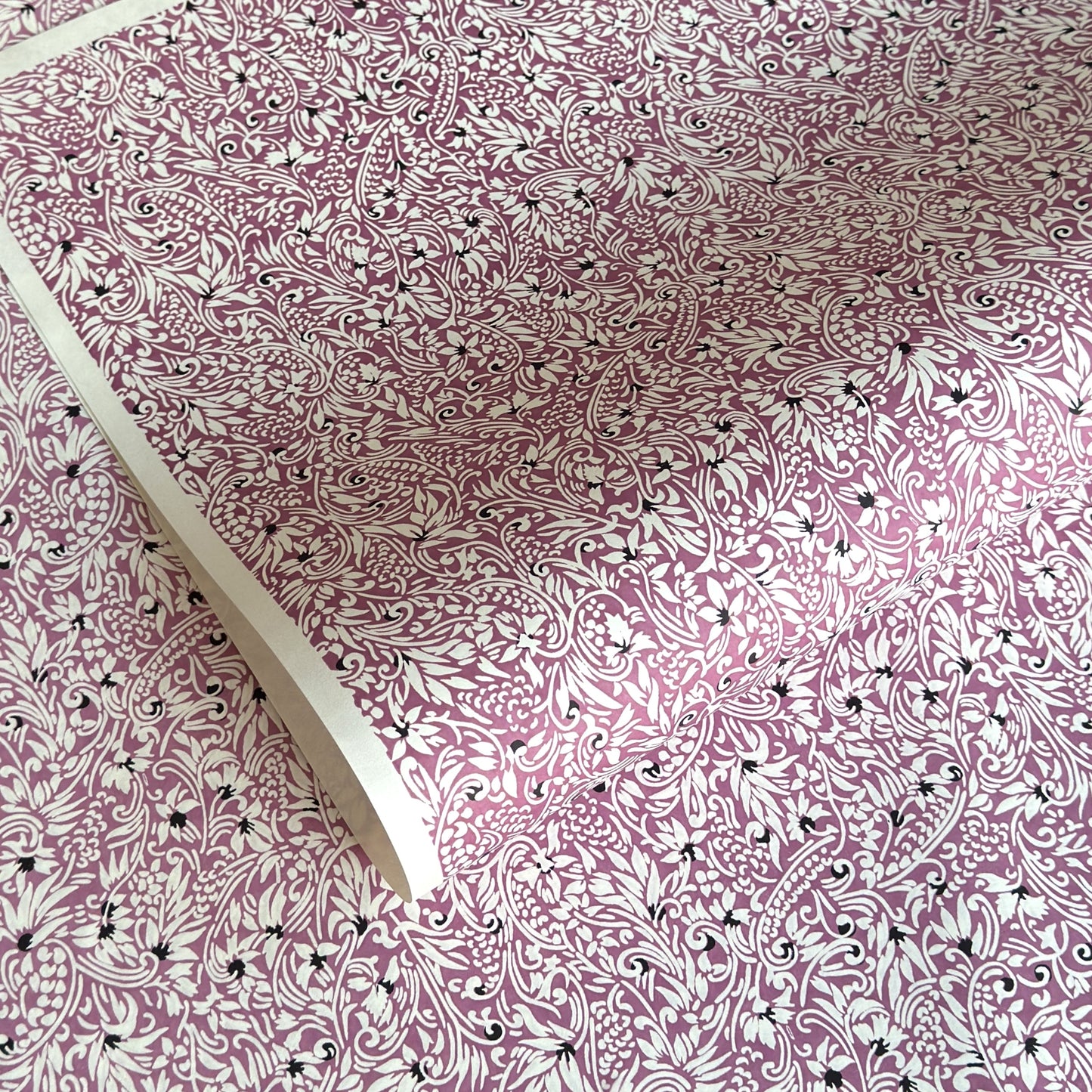 a sheet of Japanese silkscreen printed chiyogami yuzen paper with a micro floral pattern in aubergine, white and black