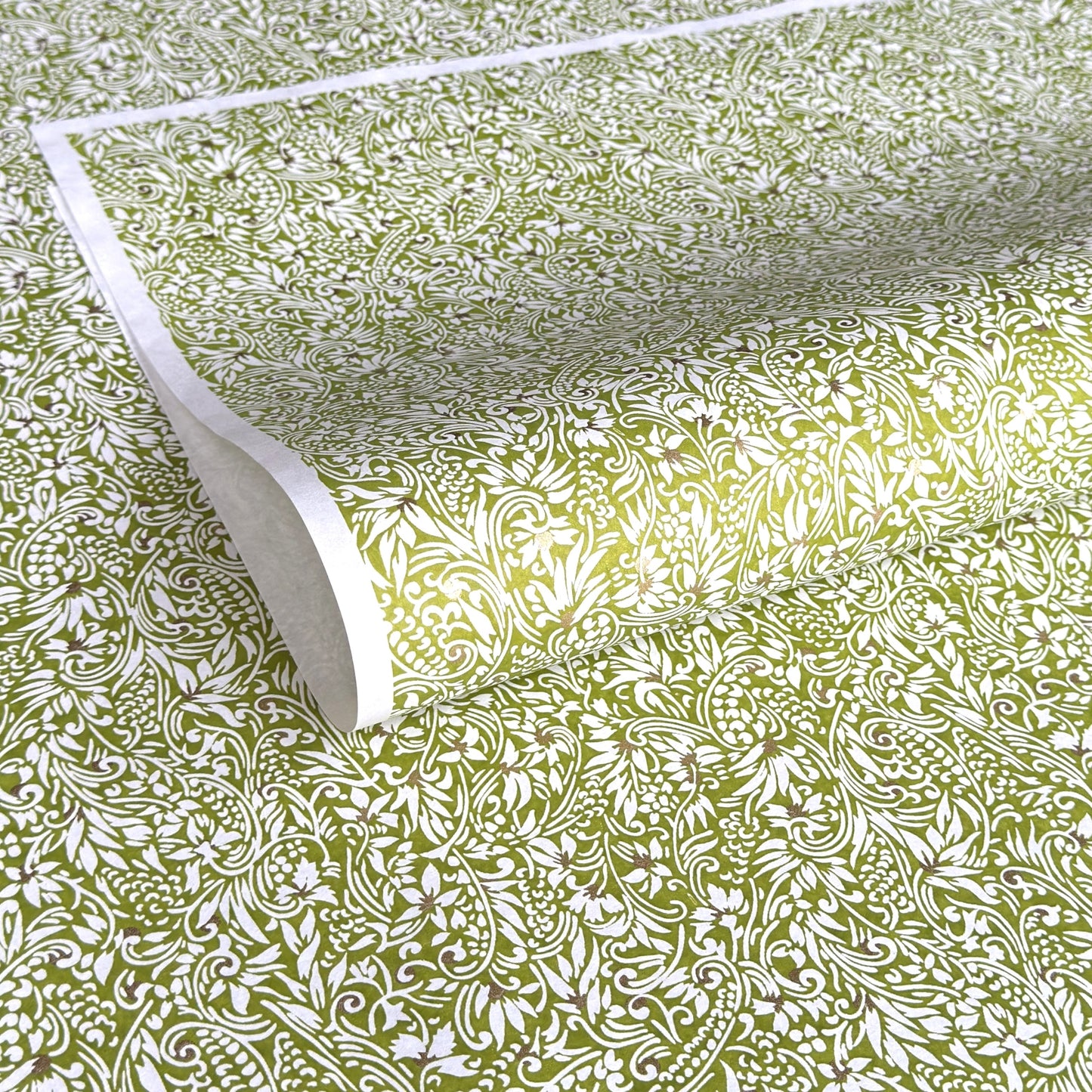 japanese silk-screen handmade paper showing green and white botanical repeat pattern with gold highlights