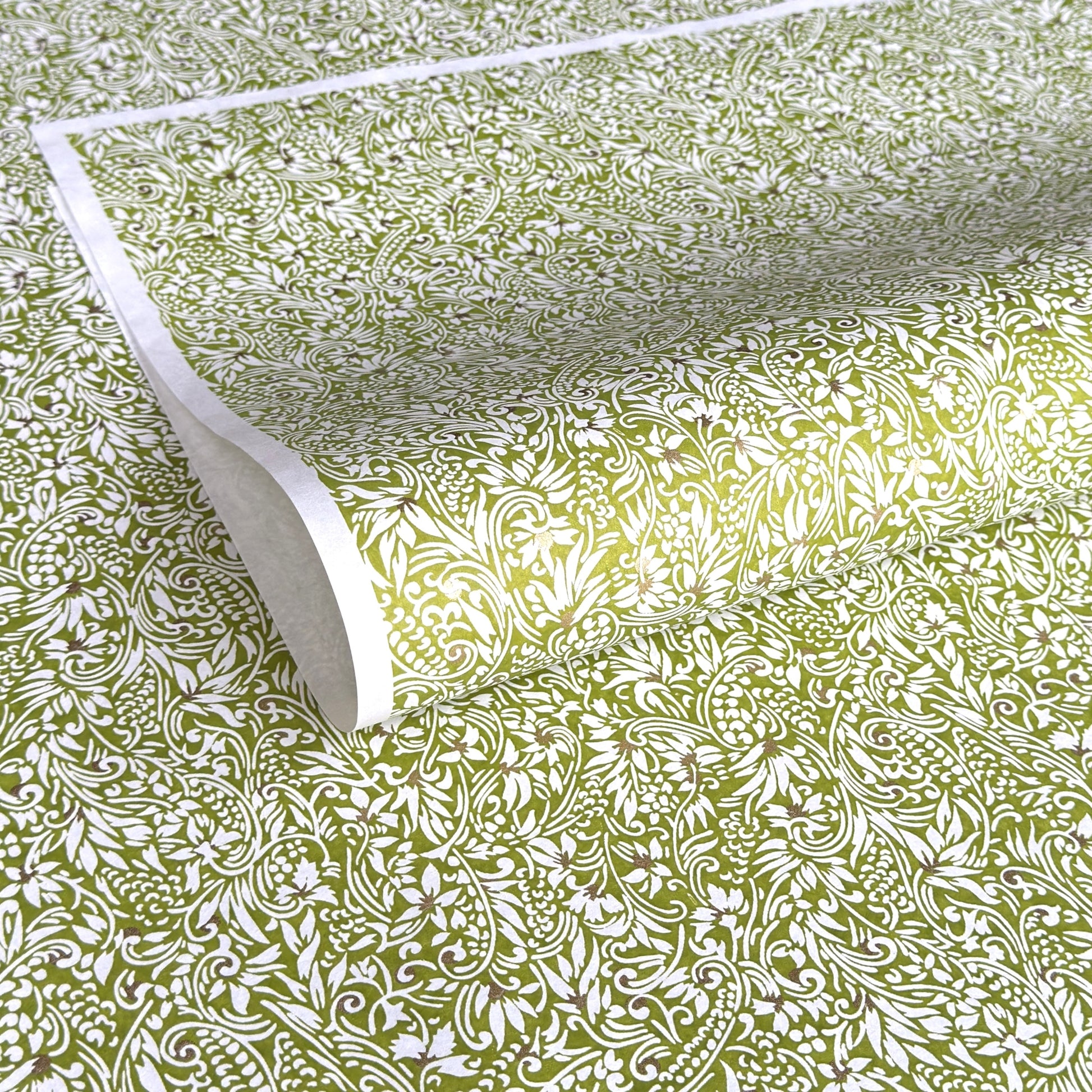 japanese silk-screen handmade paper showing green and white botanical repeat pattern with gold highlights