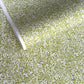 japanese silk-screen handmade paper showing green and white botanical repeat pattern with gold highlights