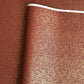 a sheet of Japanese chiyogami yuzen paper with a ditsy gold floral design on a deep red
