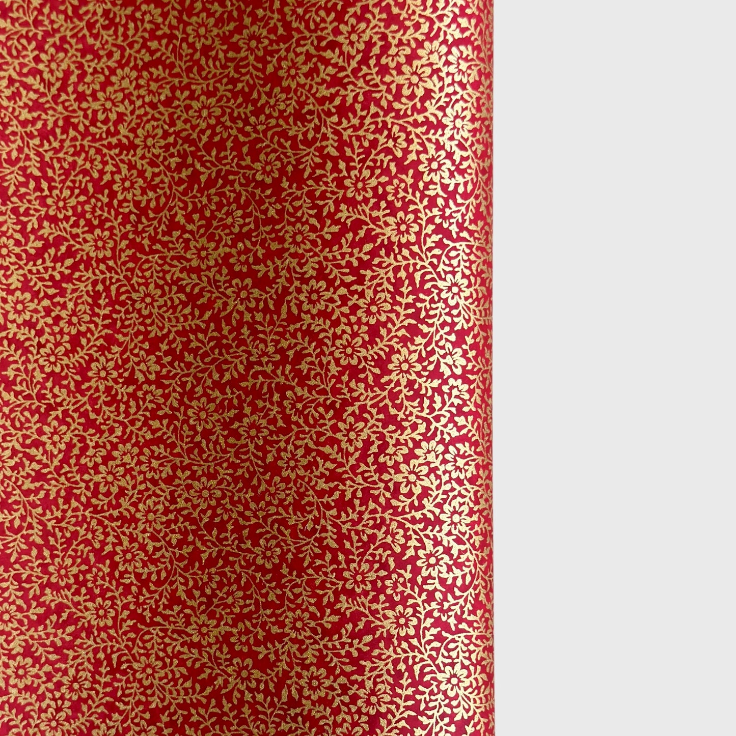 a sheet of Japanese chiyogami yuzen paper with a ditsy gold floral design on a deep red