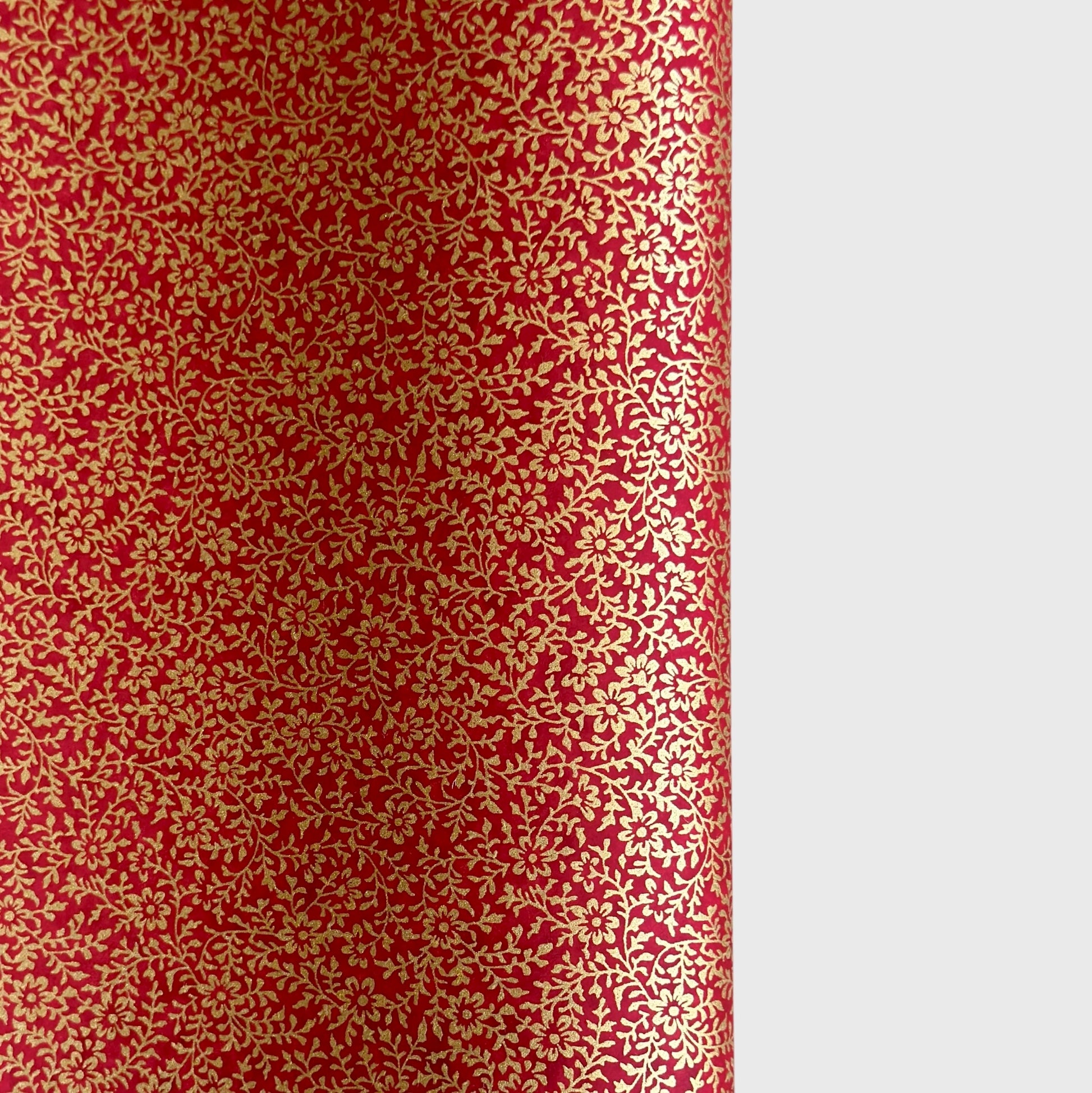 a sheet of Japanese chiyogami yuzen paper with a ditsy gold floral design on a deep red