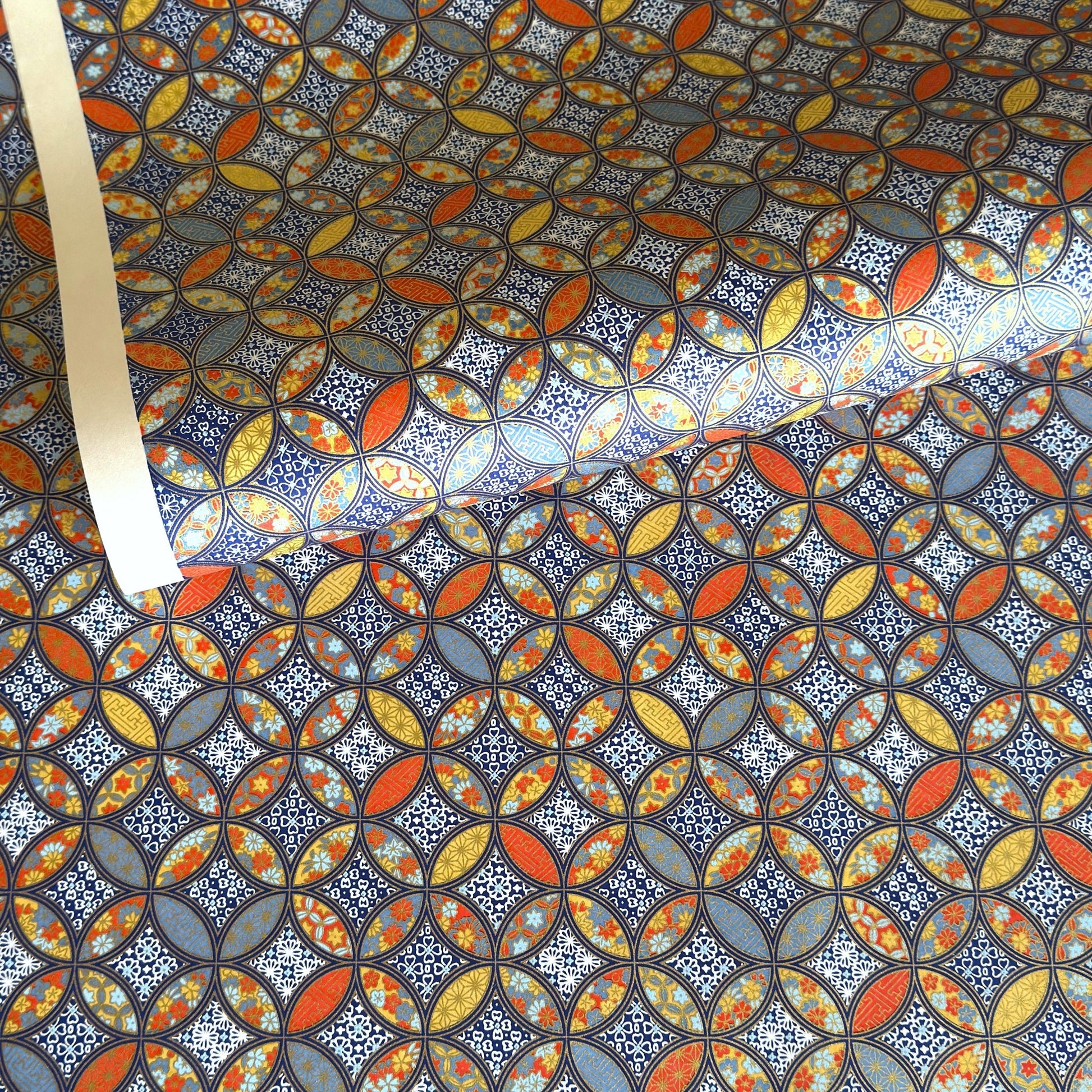 a sheet of Japanese silkscreen printed chiyogami yuzen paper with a design of overlapping circles in blue, red, yellow and white