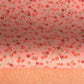 japanese silk-screen handmade paper showing pattern of red falling leaves on coral backdrop and gold highlights