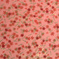 japanese silk-screen handmade paper showing pattern of red falling leaves on coral backdrop and gold highlights