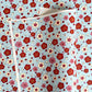 japanese silk-screen handmade paper showing red and pink plum flowers on a blue geometric backdrop