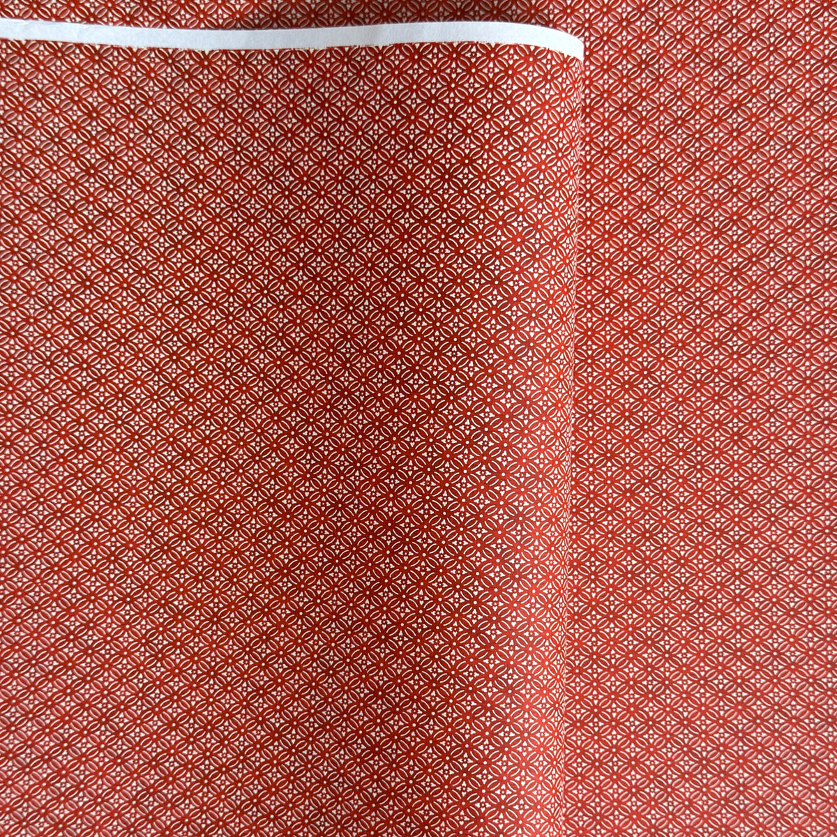 Japanese silkscreen chiyogami paper with a two-tone rich red geometric pattern on creamy white