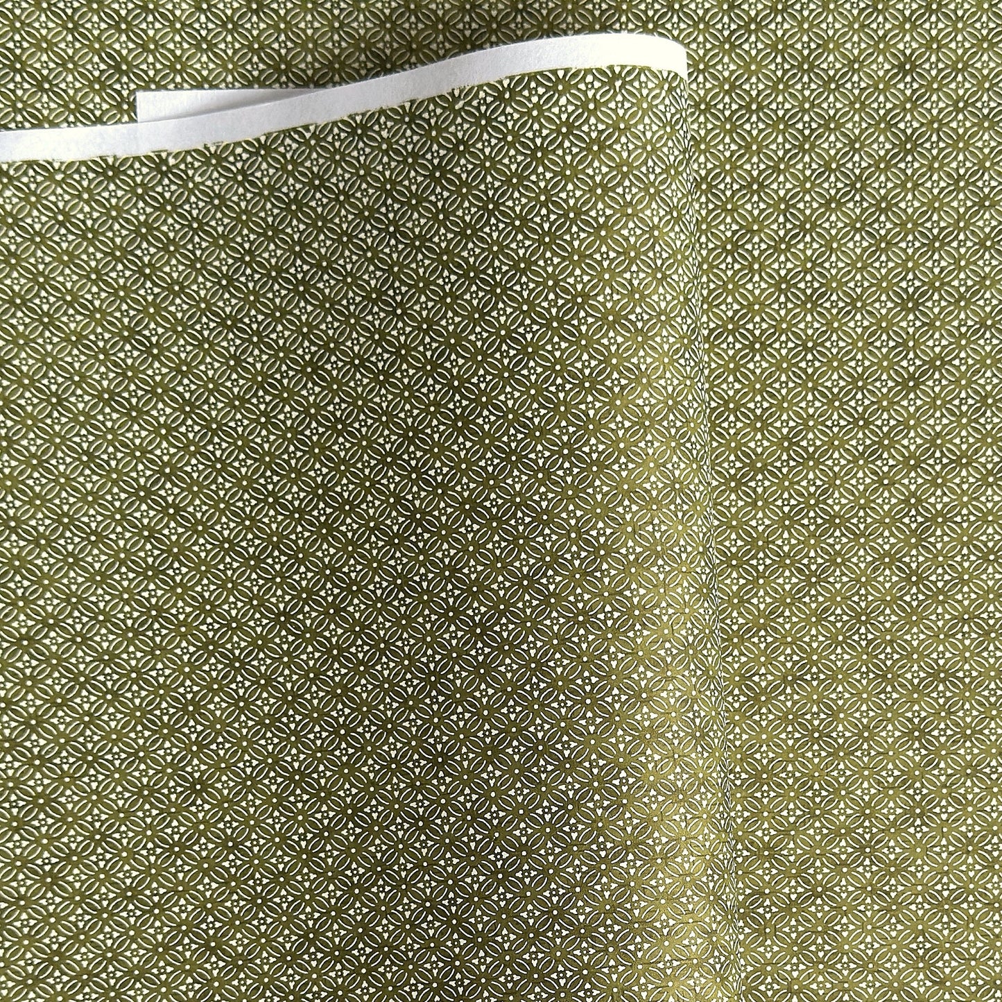 Japanese silkscreen chiyogami paper with a two-tone rich green geometric pattern on creamy white