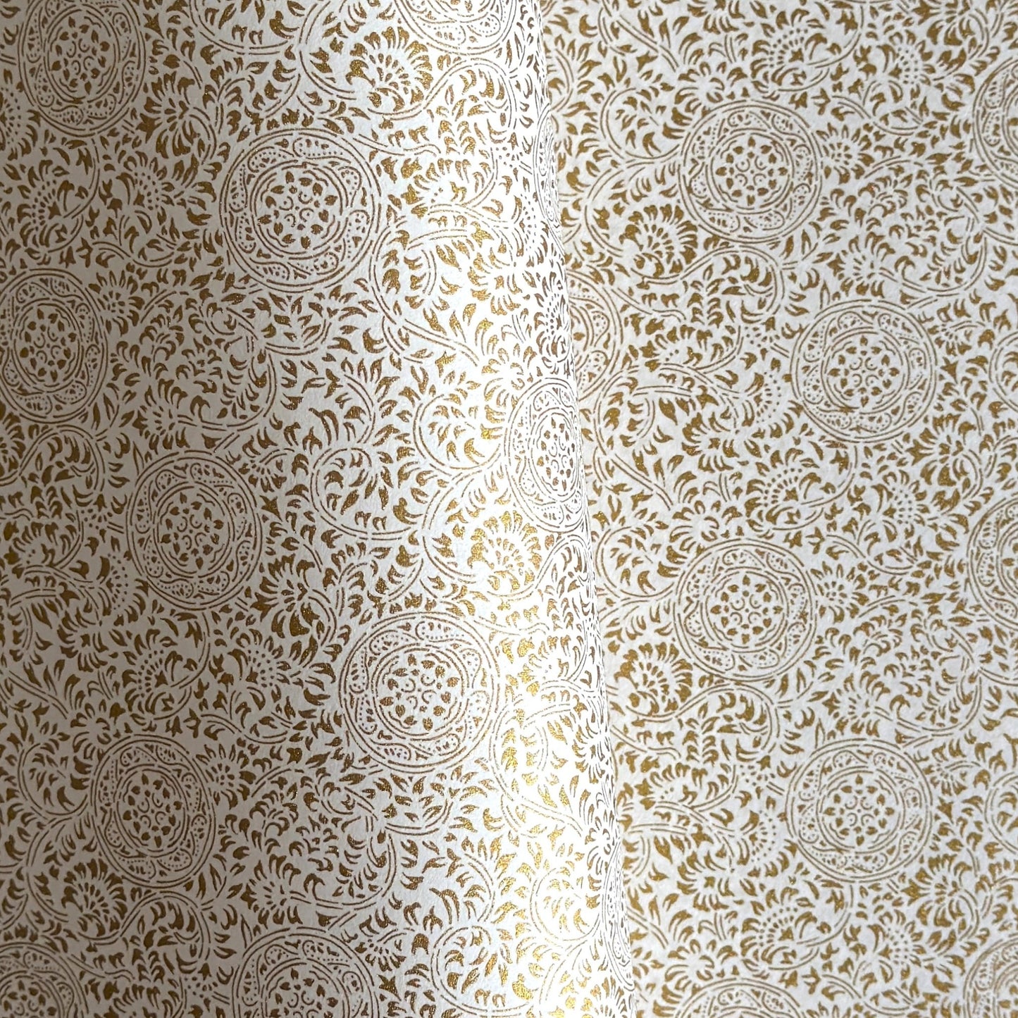 Japanese silkscreen chiyogami paper with an intricate floral pattern in gold on ivory white.