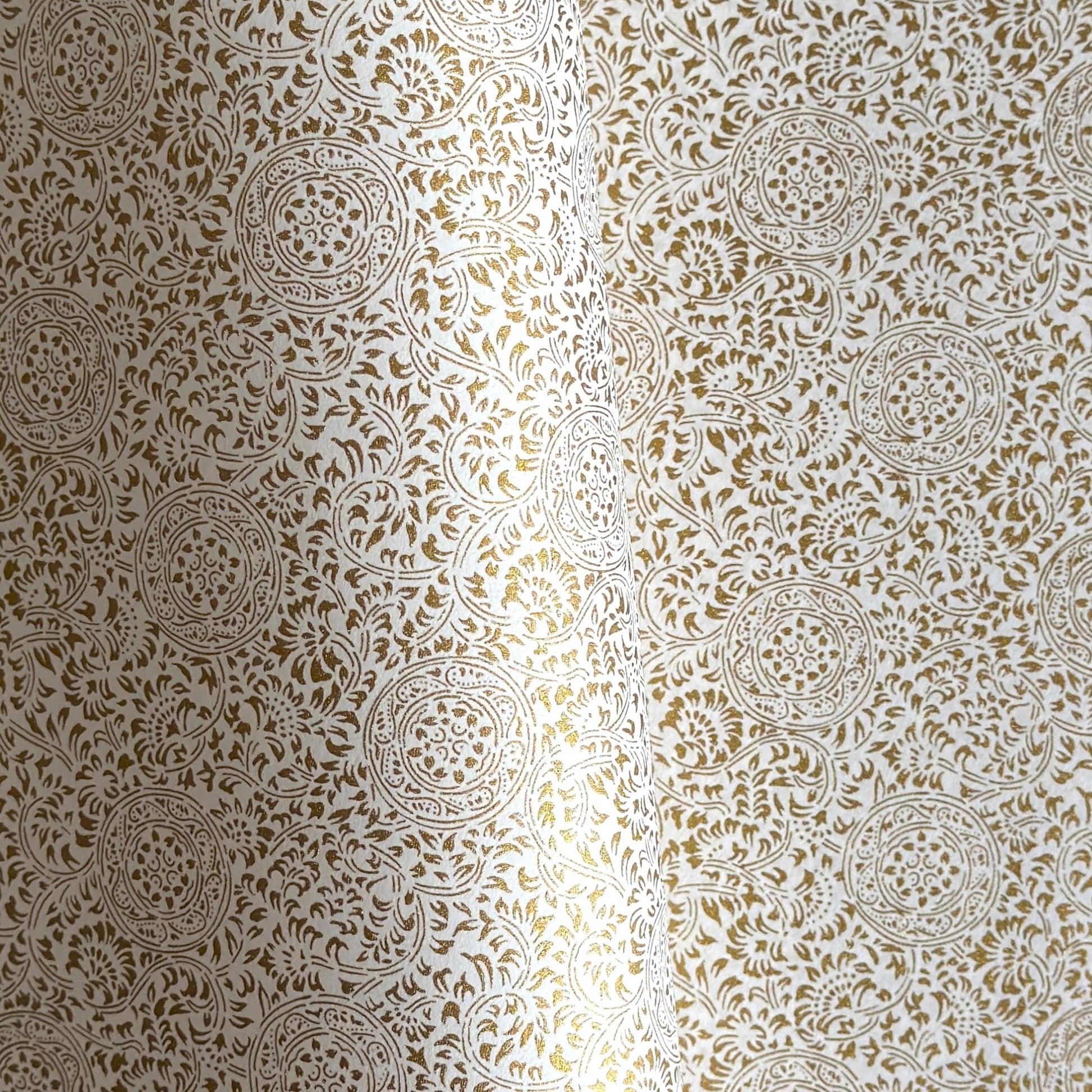 Japanese silkscreen chiyogami paper with an intricate floral pattern in gold on ivory white.