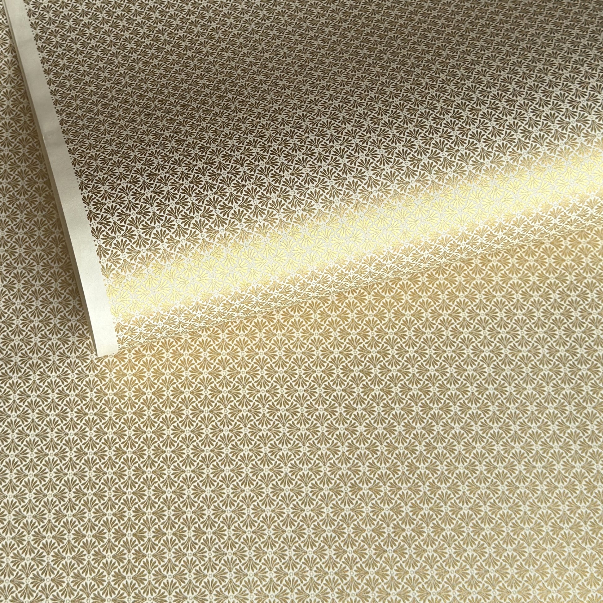 a sheet of Japanese silkscreen printed chiyogami yuzen paper with a micro gold geometric pattern on white backdrop. 