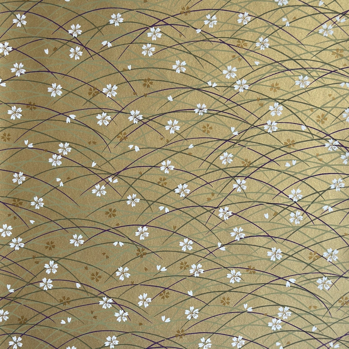 Japanese silkscreen chiyogami paper with a pattern of purple arches and white cherry blossom on antique gold backdrop