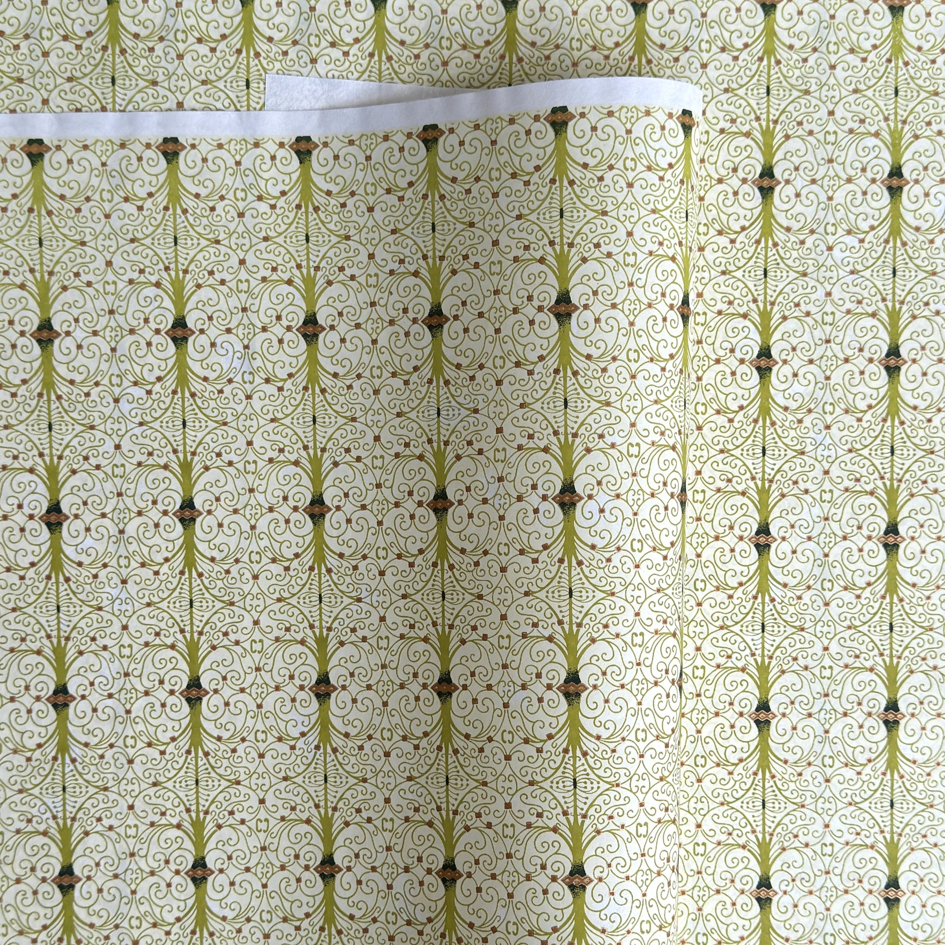 japanese silk-screen handmade paper showing green filigree pattern with gold accents