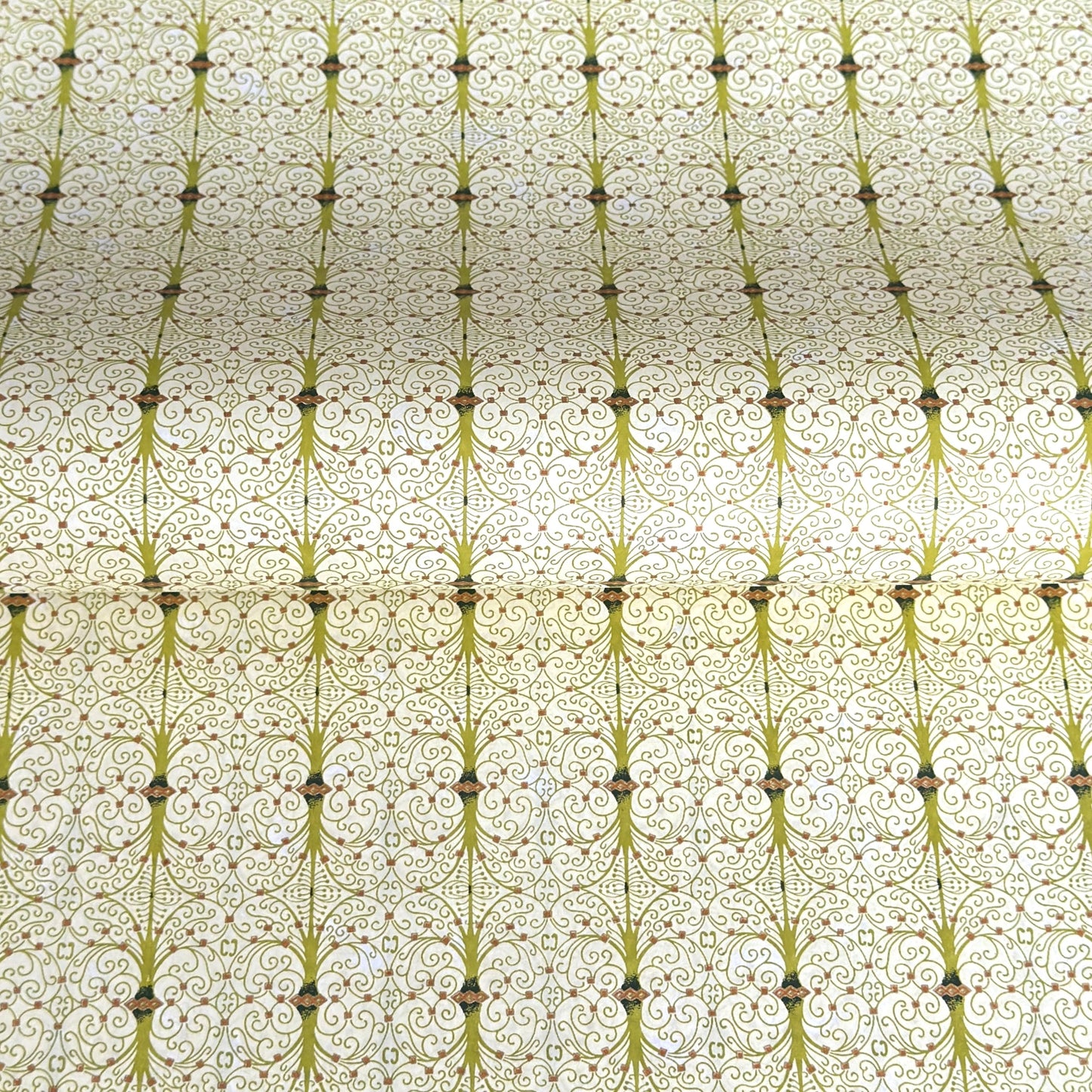 japanese silk-screen handmade paper showing green filigree pattern with gold accents