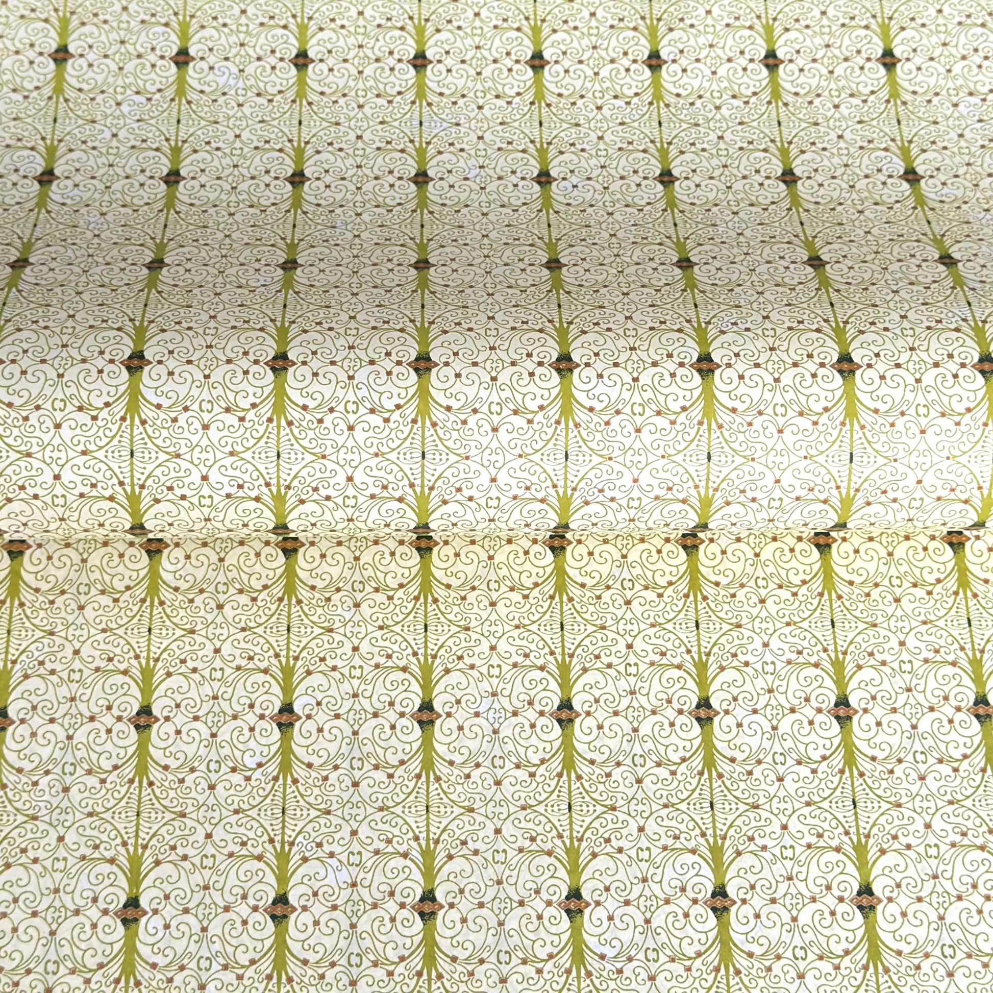 japanese silk-screen handmade paper showing green filigree pattern with gold accents