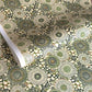 Japanese silkscreen chiyogami paper with a repeat pattern of stylised chrysanthemum flowers in tones of deep green on a buttermilk cream backdrop.