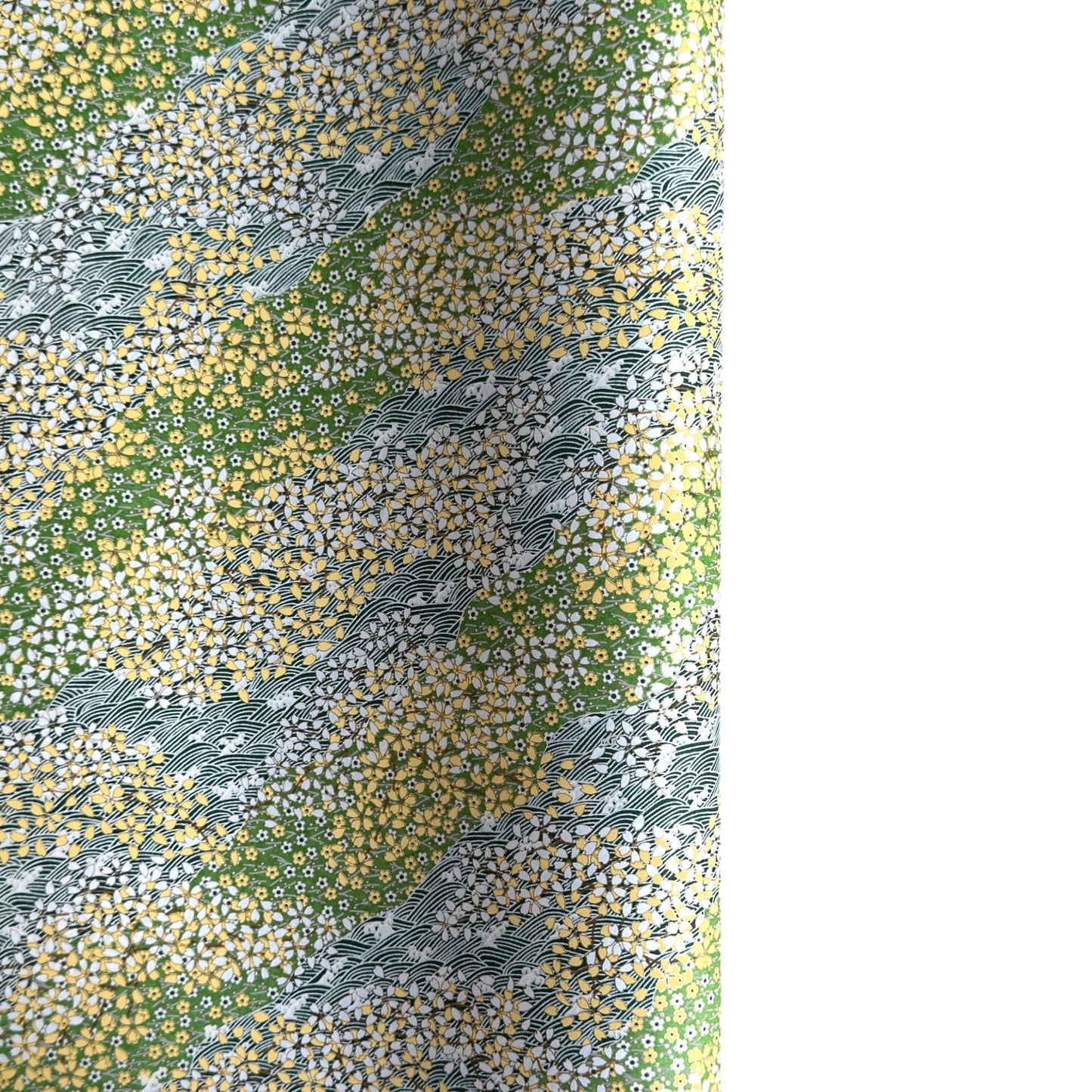 Japanese silkscreen chiyogami paper with a pattern of dark green rivers and grass green banks with an abundance of little flowers in white and yellow