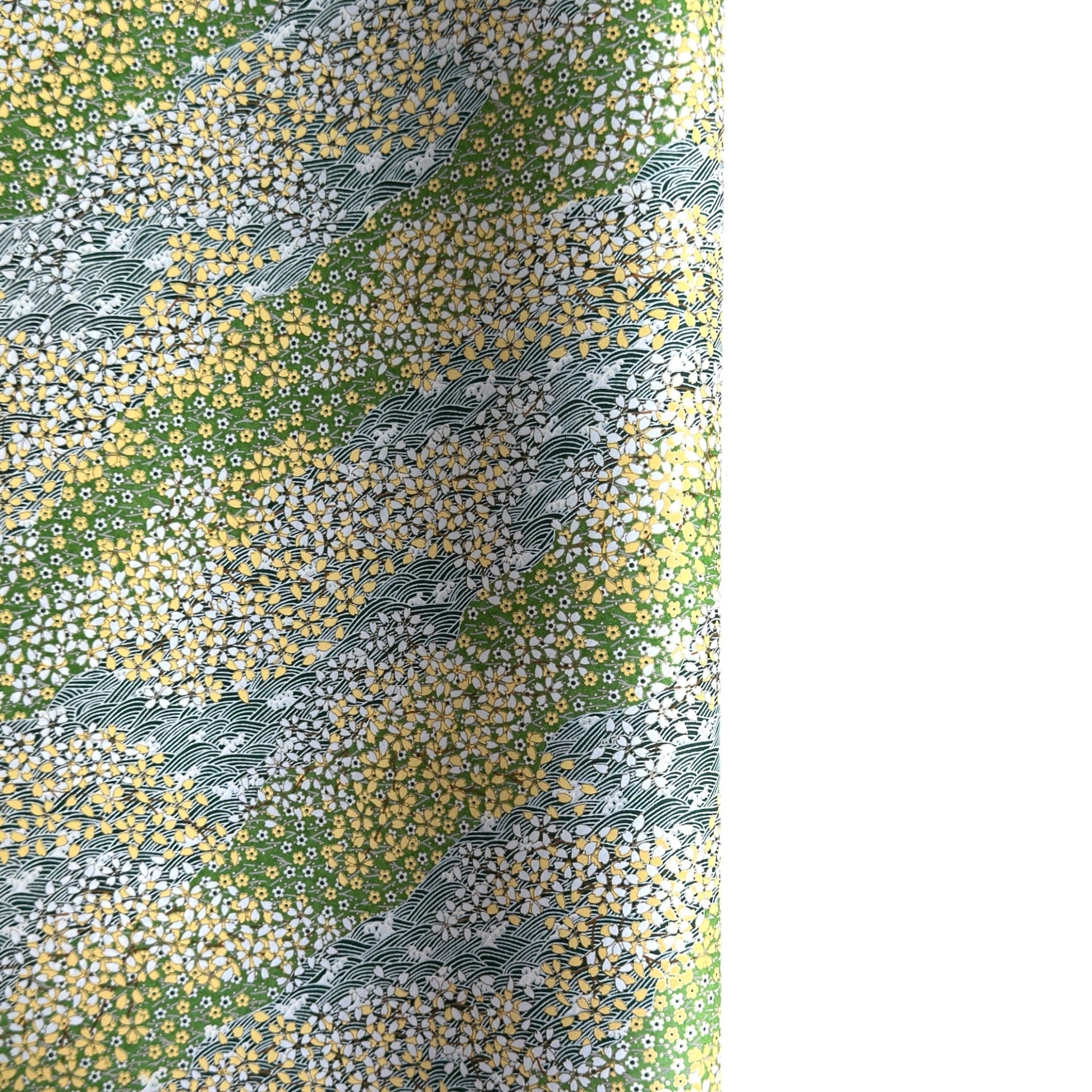 Japanese silkscreen chiyogami paper with a pattern of dark green rivers and grass green banks with an abundance of little flowers in white and yellow