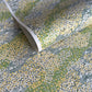 Japanese silkscreen chiyogami paper with a pattern of dark green rivers and grass green banks with an abundance of little flowers in white and yellow