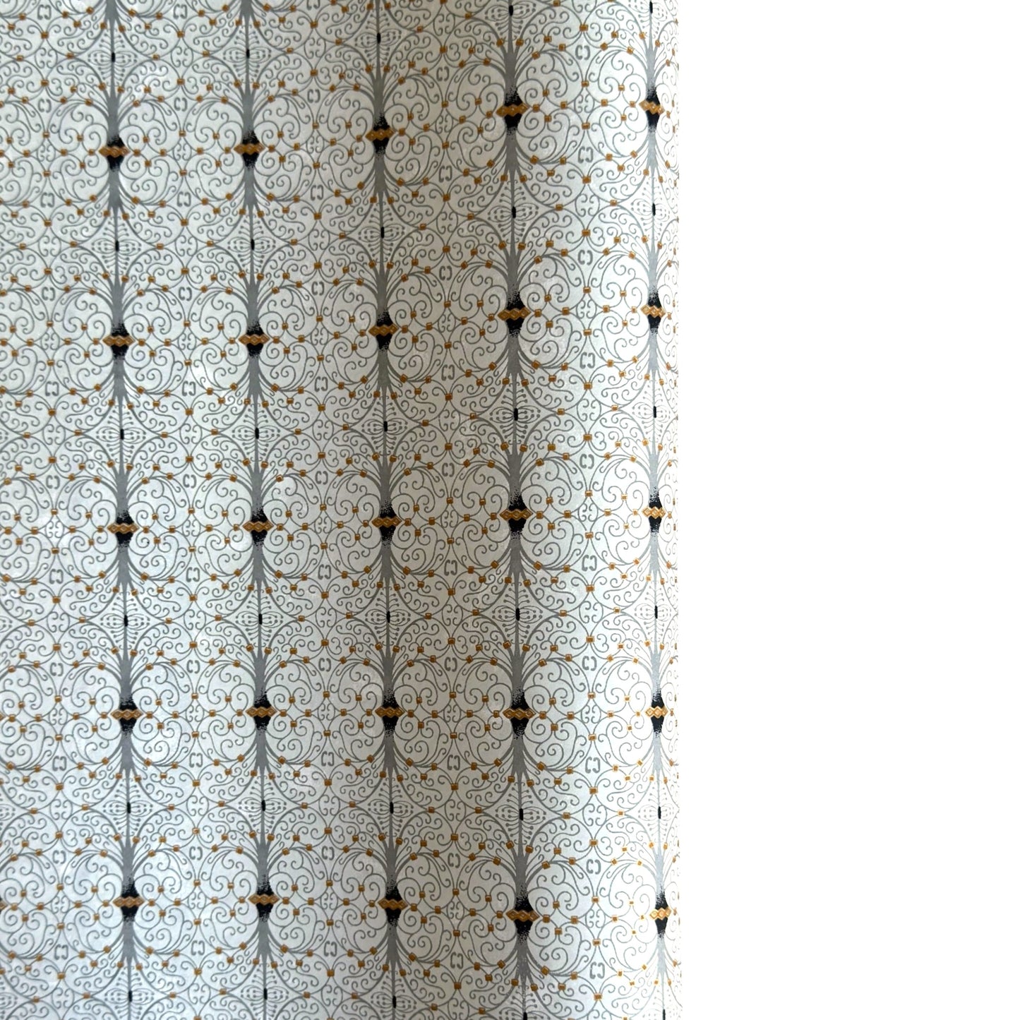 Japanese silkscreen chiyogami paper with a intricate filigree trellis design in grey with gold accent