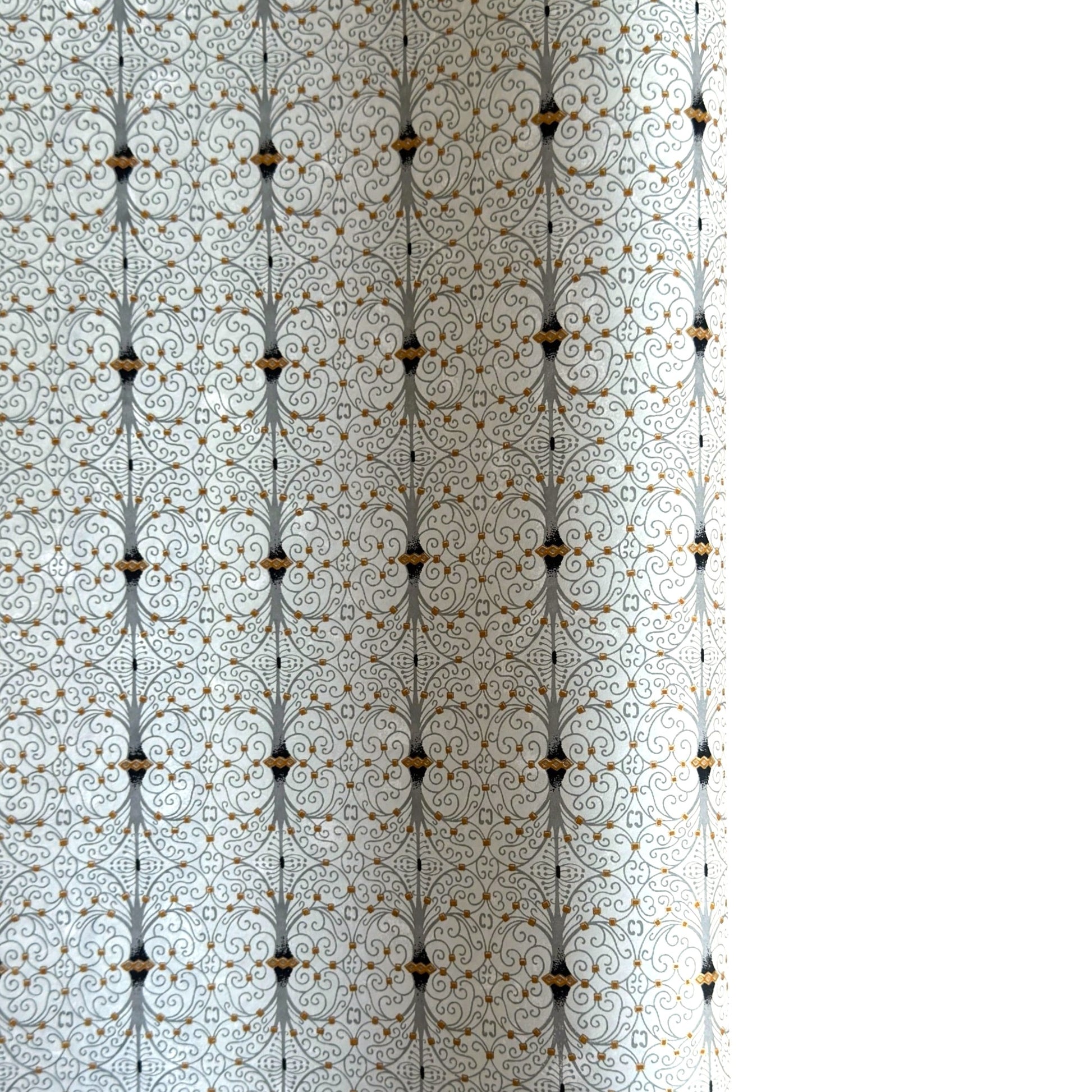 Japanese silkscreen chiyogami paper with a intricate filigree trellis design in grey with gold accent