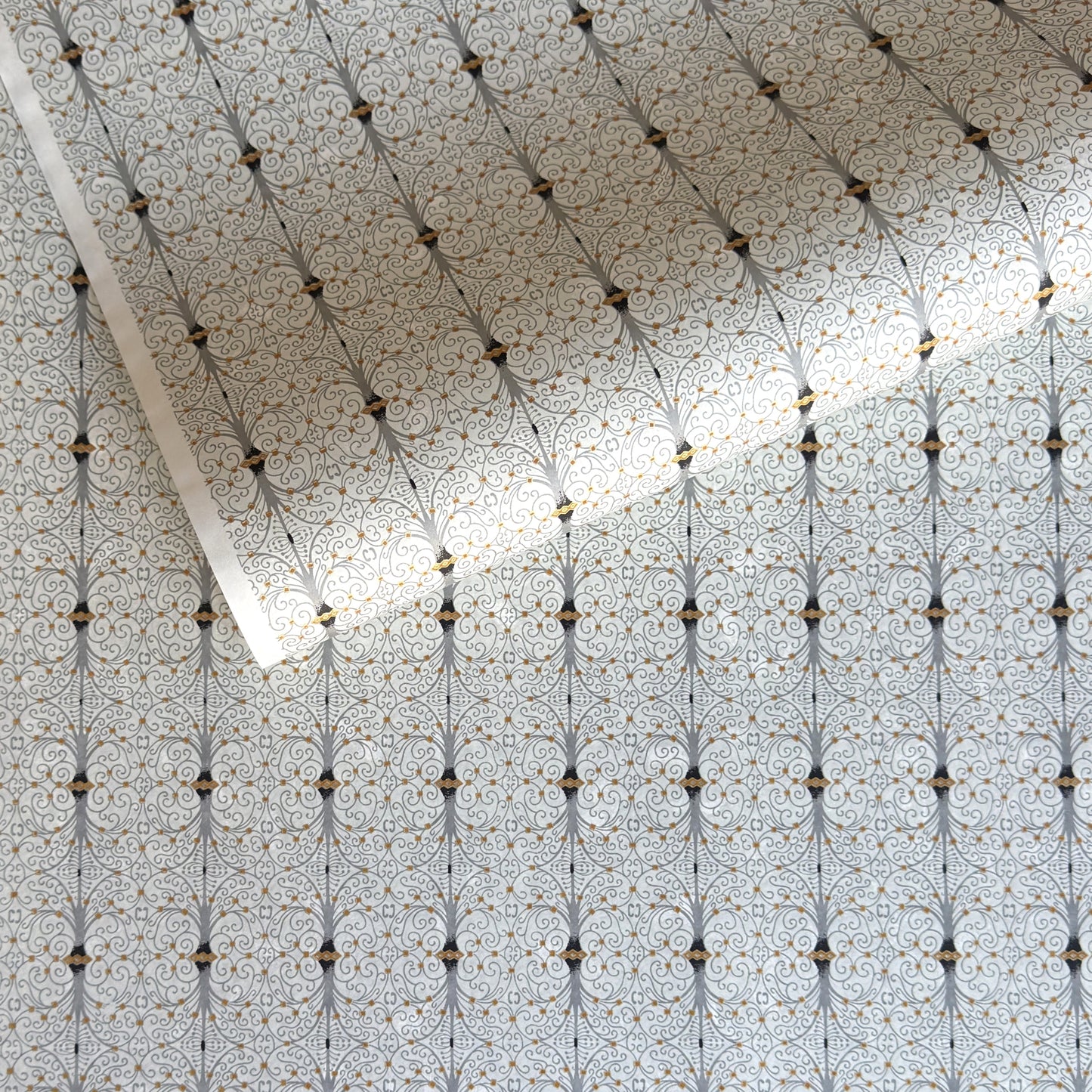 Japanese silkscreen chiyogami paper with a intricate filigree trellis design in grey with gold accent