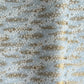 a sheet of Japanese silkscreen printed chiyogami paper with waves of tiny white and gold flowers on a soft aqua background with a dusting of gold.