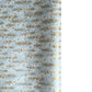 a sheet of Japanese silkscreen printed chiyogami paper with waves of tiny white and gold flowers on a soft aqua background with a dusting of gold.
