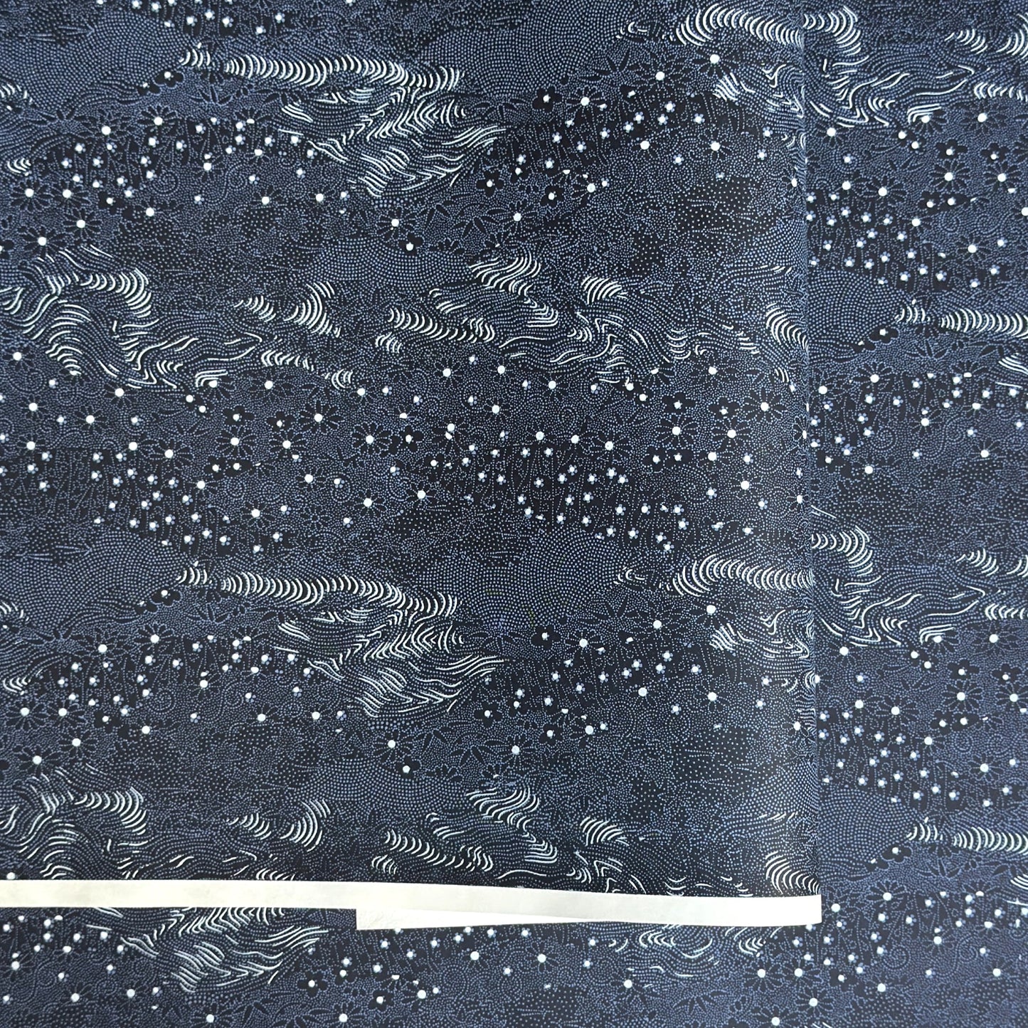 Japanese chiyogami paper.  Inky blue with a subtle pattern of a riverbank of flowers.  