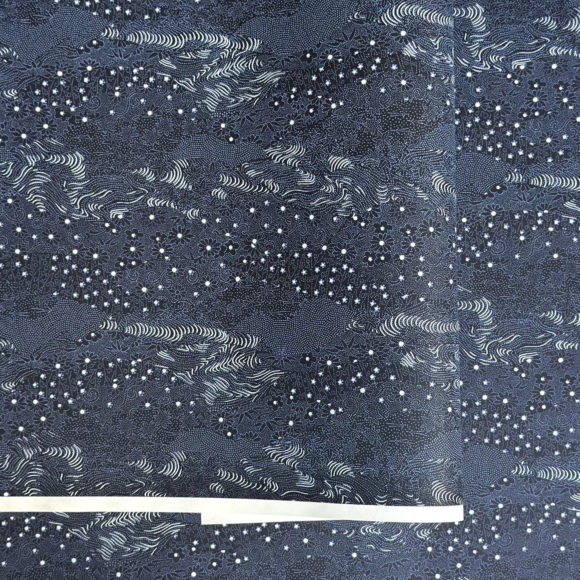 Japanese chiyogami paper.  Inky blue with a subtle pattern of a riverbank of flowers.  
