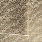 a sheet of Japanese silkscreen printed chiyogami paper with waves of tiny white and gold flowers on a soft taupe background with a dusting of gold.
