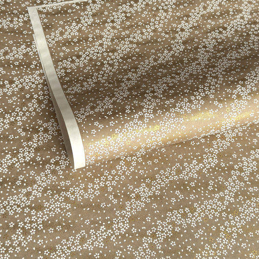 a sheet of Japanese silkscreen printed chiyogami paper with waves of tiny white and gold flowers on a soft taupe background with a dusting of gold.