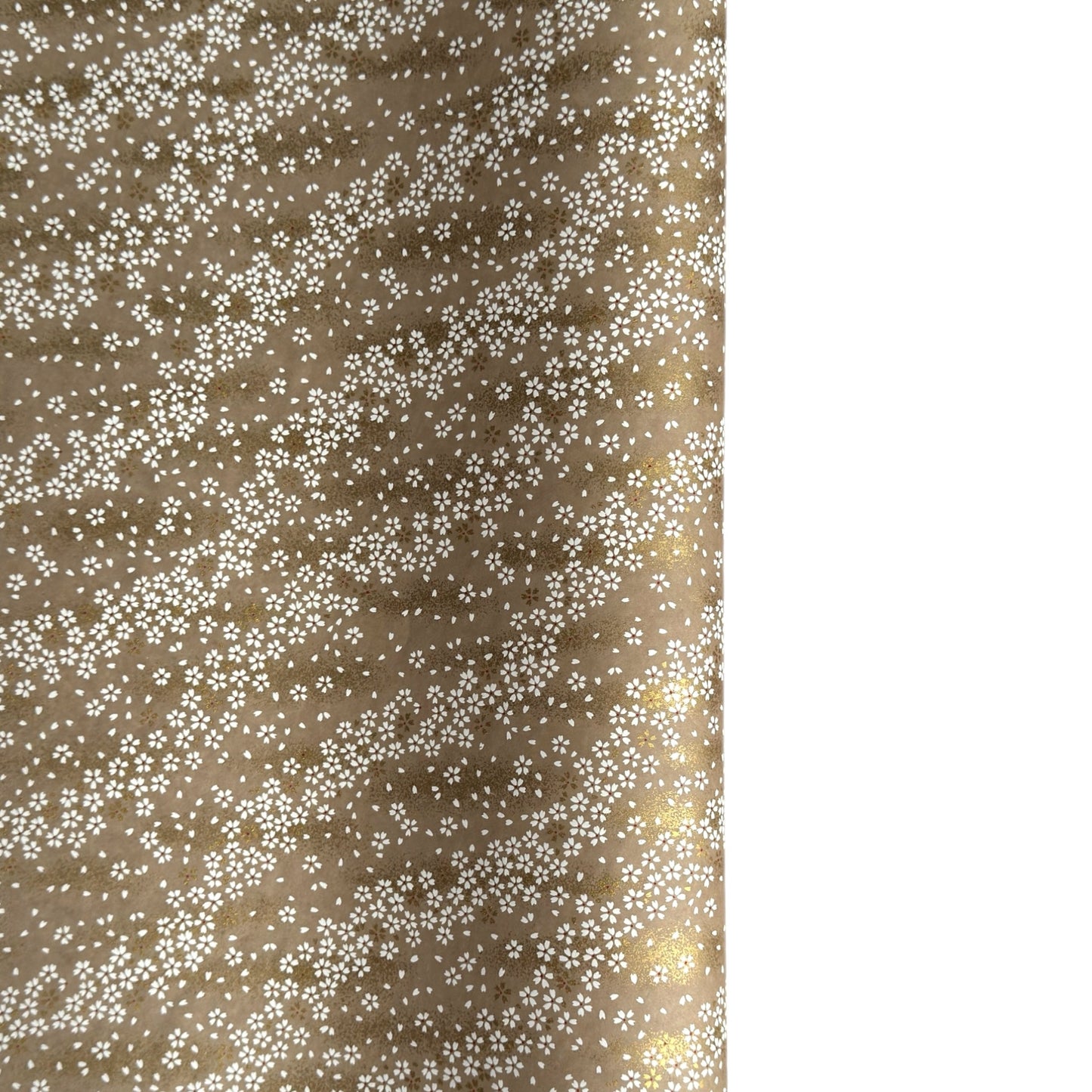 a sheet of Japanese silkscreen printed chiyogami paper with waves of tiny white and gold flowers on a soft taupe background with a dusting of gold.