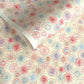 japanese chiyogami silkscreen printed paper with a pattern of fireworks in reds, pinks and lilacs on an ivory background.