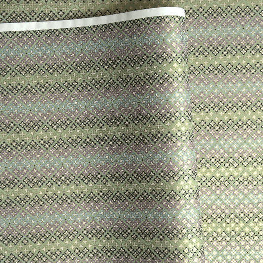 Japanese silkscreen chiyogami paper with a repeat pattern of stripes of a small floral motif in black, lilac and blue on a moss green backdrop