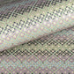 Japanese silkscreen chiyogami paper with a repeat pattern of stripes of a small floral motif in black, lilac and blue on a moss green backdrop