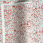 a sheet of japanese silkscreen printed chiyogami paper with a pattern of gold rivers, red falling leaves on a soft aqua background