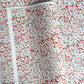 a sheet of japanese silkscreen printed chiyogami paper with a pattern of gold rivers, red falling leaves on a soft aqua background