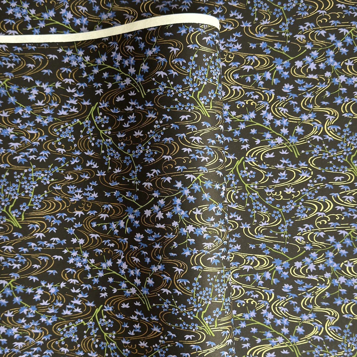 Gold rivers (kawa) with purple falling leaves (fukiyose) and foliage on a black backdrop. Japanese chiyogami paper