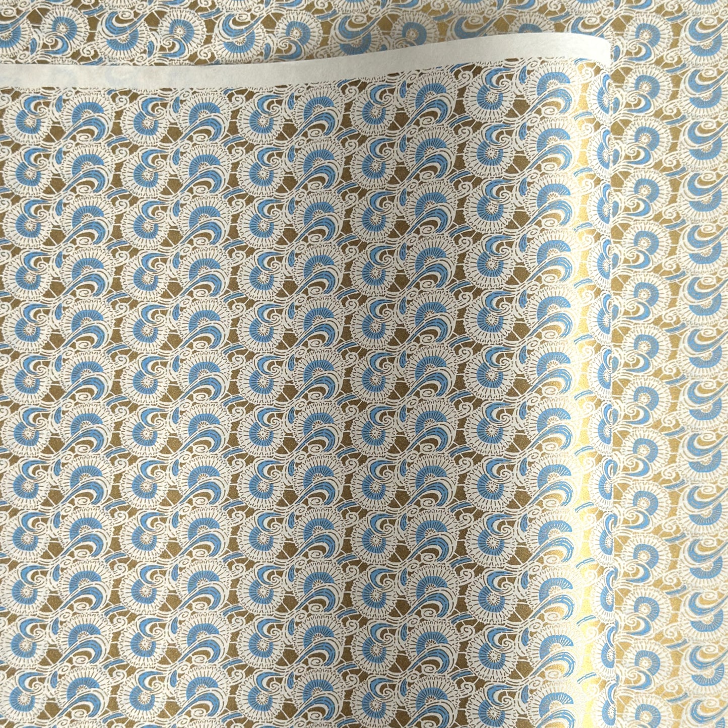 Japanese silkscreen chiyogami paper with a repeat floral pattern in gold an cerulean blue