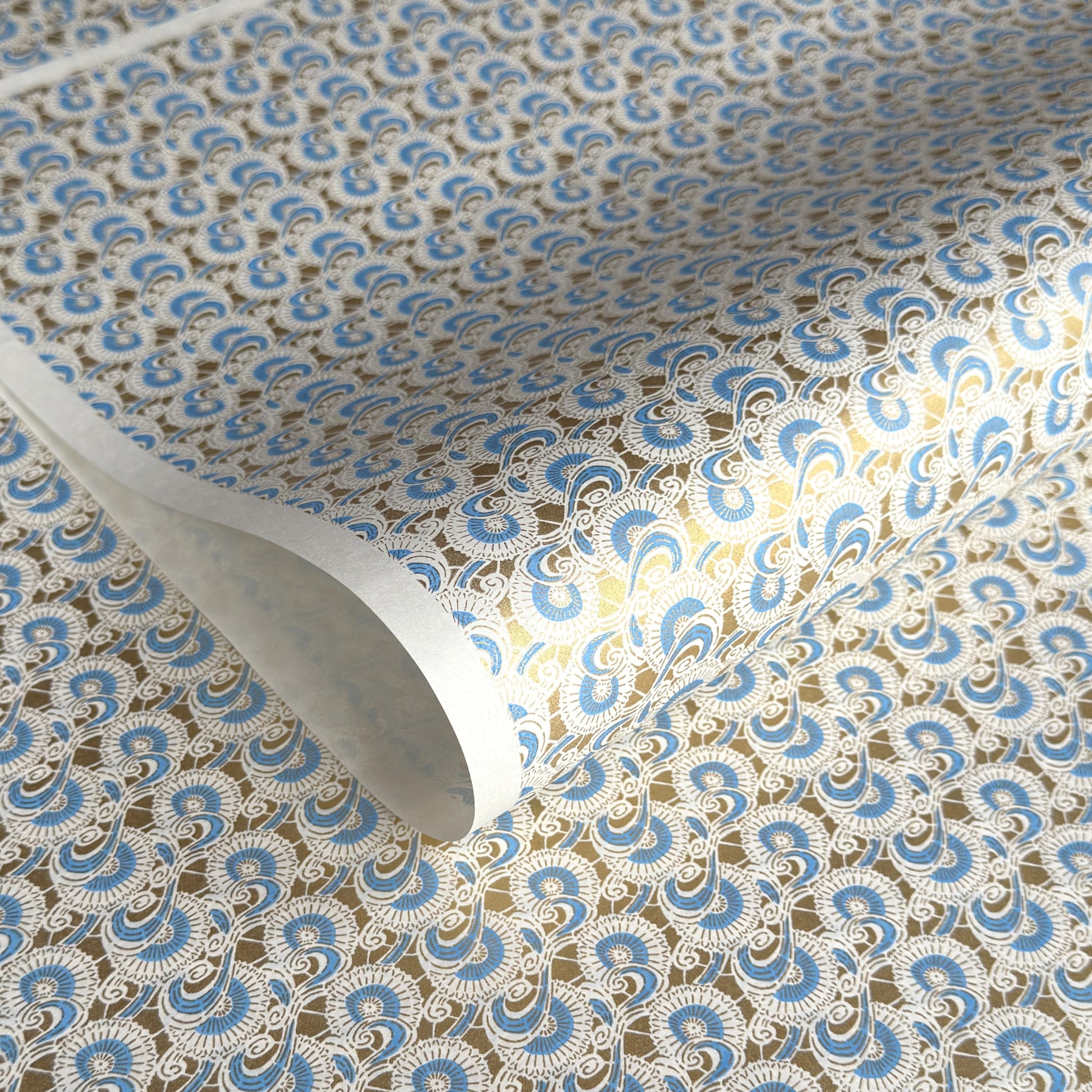 Japanese silkscreen chiyogami paper with a repeat floral pattern in gold an cerulean blue
