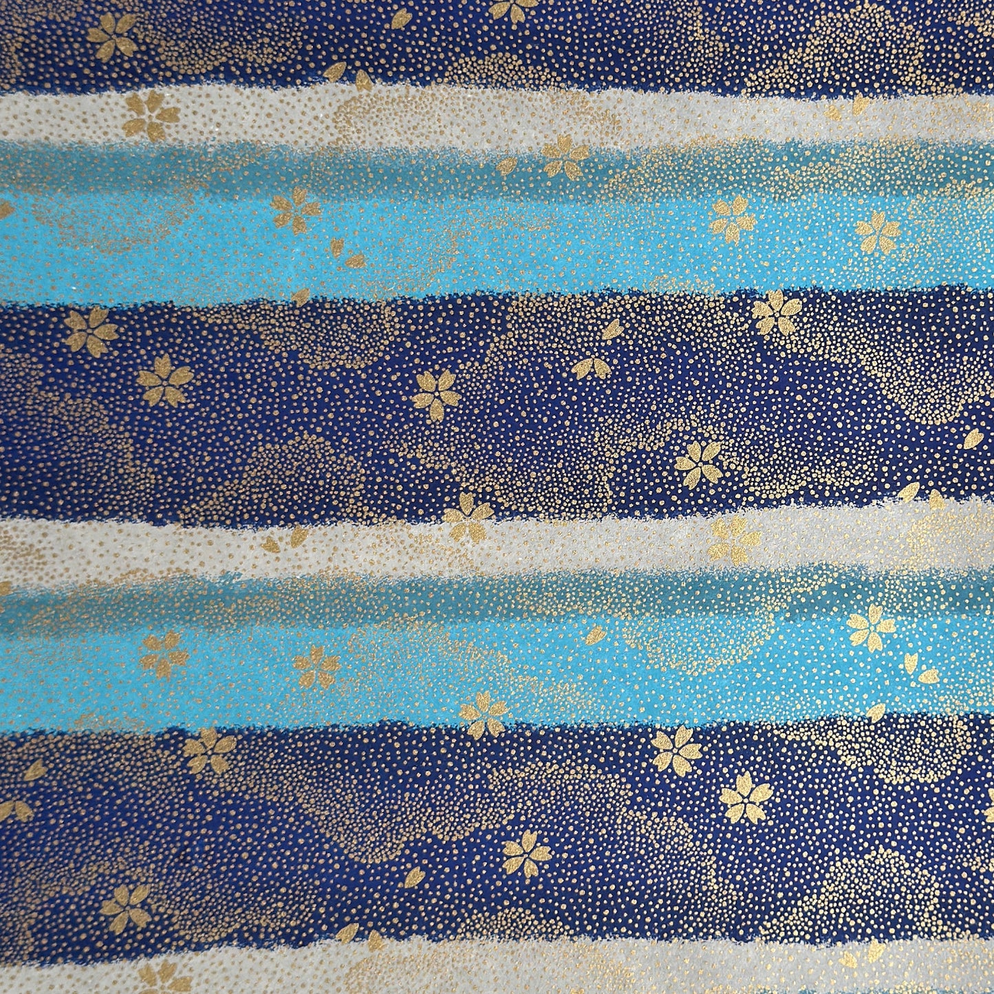 japanese chiyogami paper in stripes of blue, turquoise and grey with gold clouds and flowers