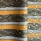 japanese chiyogami paper in stripes of black, brown, ochre and grey with gold clouds and flowers