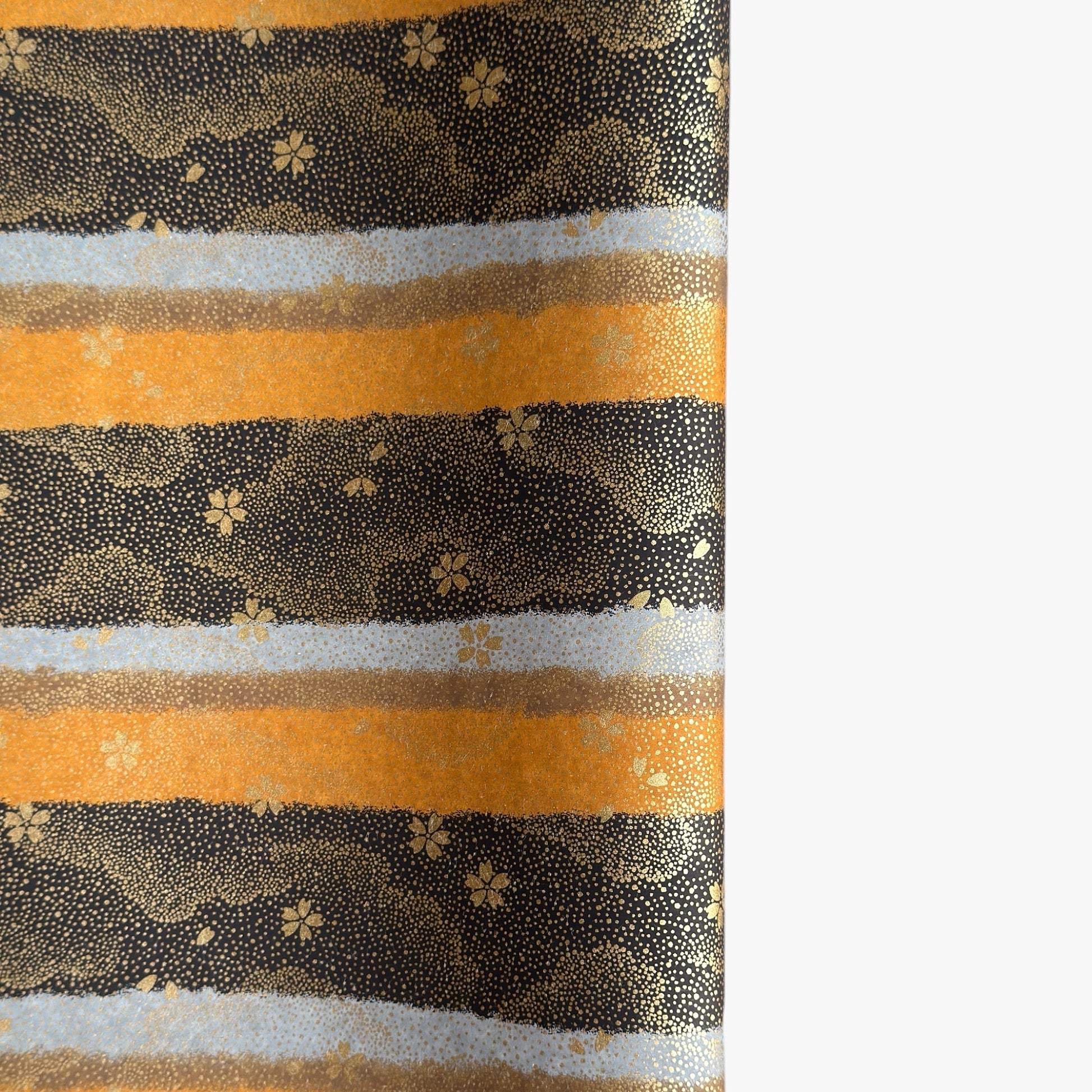 japanese chiyogami paper in stripes of black, brown, ochre and grey with gold clouds and flowers