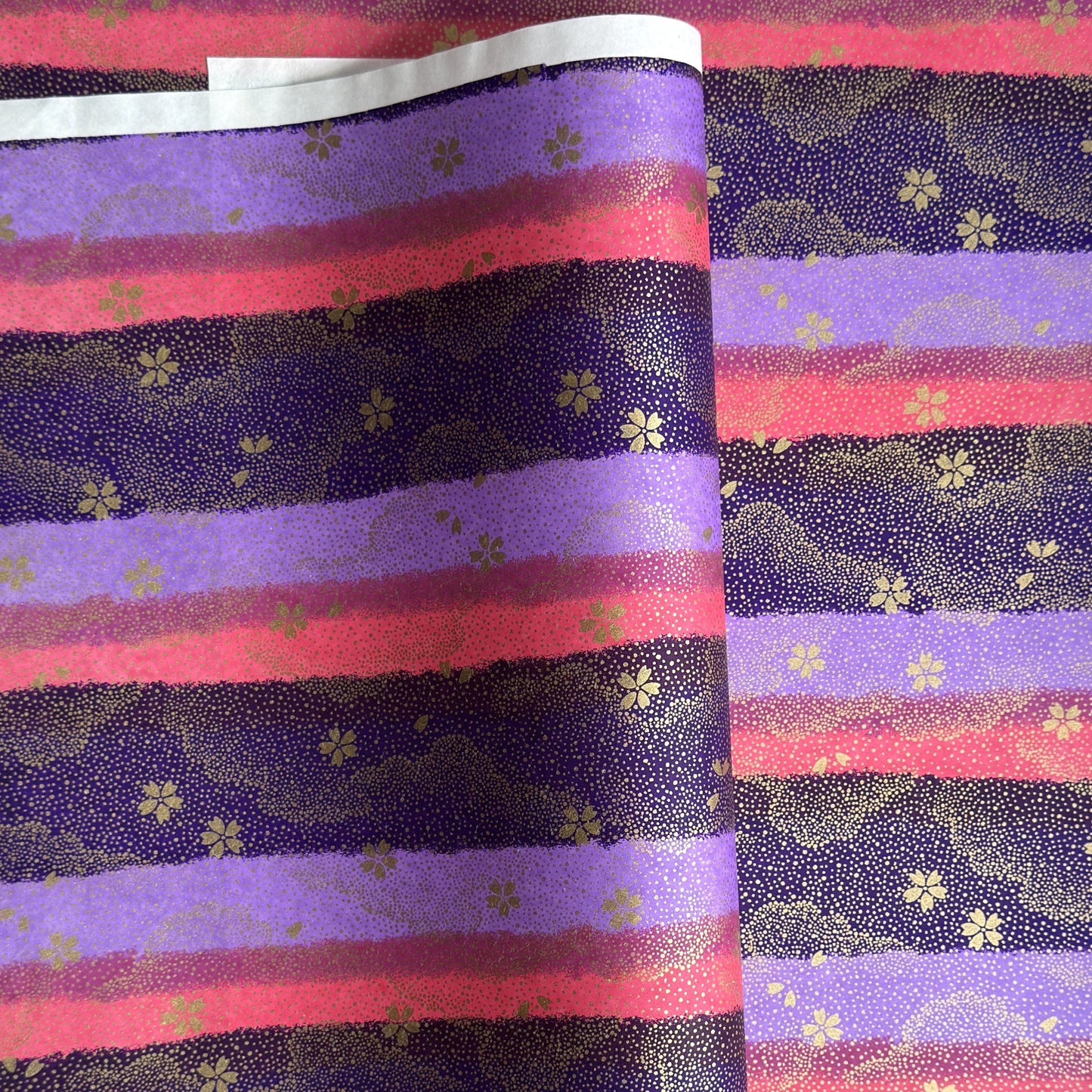 japanese chiyogami paper in stripes of pink, lilac and purple with gold clouds and flowers
