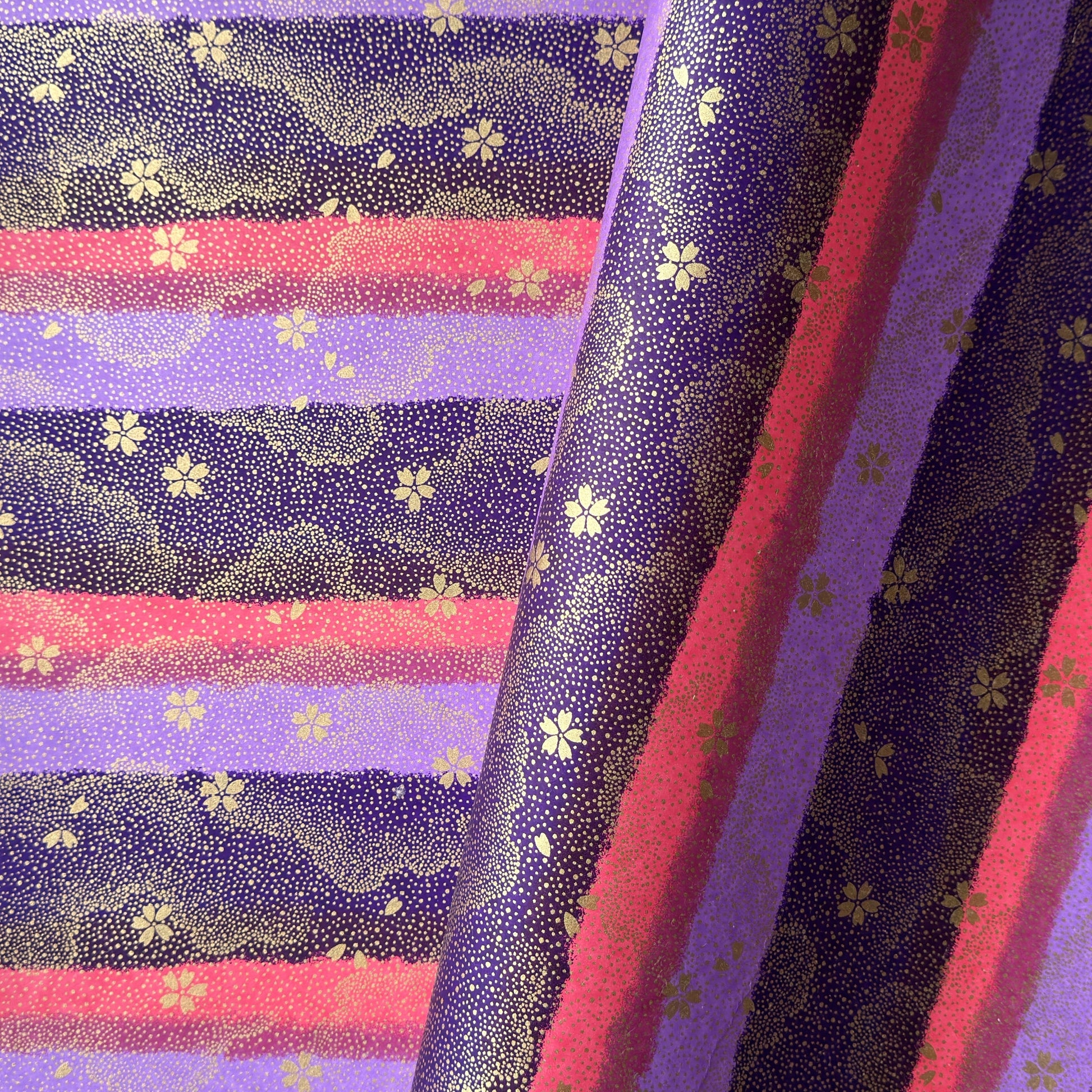 japanese chiyogami paper in stripes of pink, lilac and purple with gold clouds and flowers
